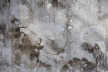 Yüzeyinde çatlaklar olan eski gri beton duvar..