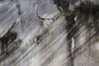 Yüzeyinde çatlaklar olan eski gri beton duvar..