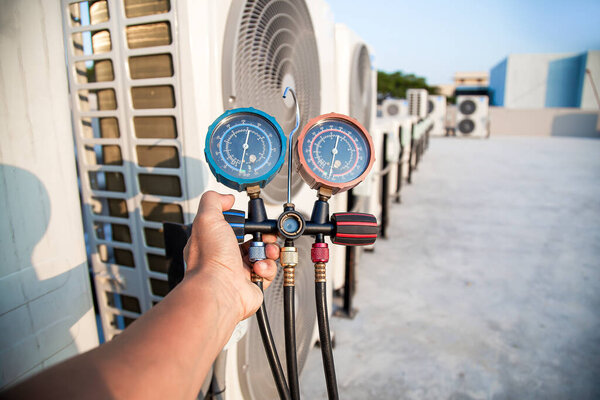 Специалист по кондиционированию проверяет работу кондиционера.