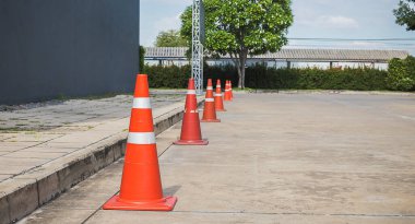 Beton yol yüzeyinde turuncu trafik konileri.