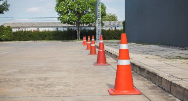 Beton yol yüzeyinde turuncu trafik konileri.
