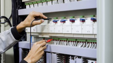 Elektrik mühendisi, kabine kontrolündeki voltaj ve elektrik hattının akımını ölçen bir testçi..