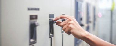 Elektrik kontrol dolaplarını denetlemek ve korumak için çalışan mühendisler.