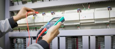 Elektrik mühendisleri elektrik kontrol cihazlarının çalışmasını test ediyor.