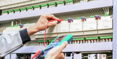 Elektrik mühendisi, kabine kontrolündeki voltaj ve elektrik hattının akımını ölçen bir testçi..