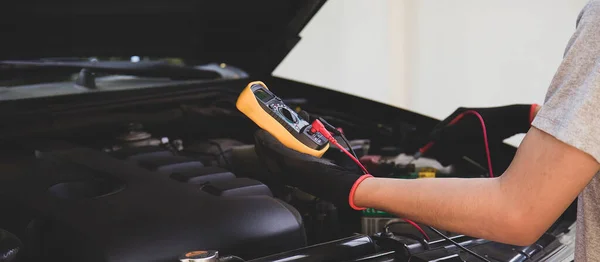 Technicians inspect the car\'s electrical system.