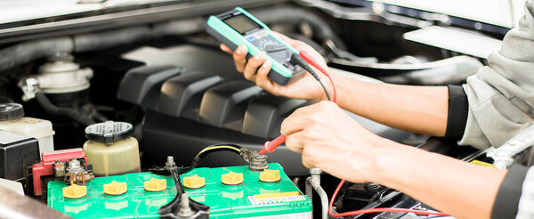 Техник проверяет наличие аккумулятора в машине..