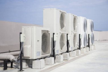 Air conditioning (HVAC) on the roof of an industrial building with blue sky.