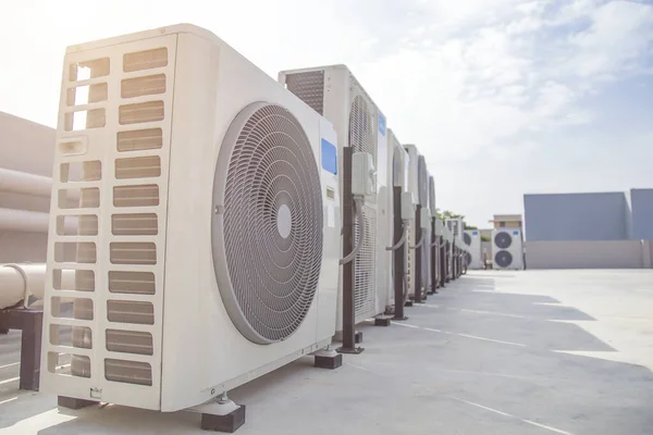 Air conditioning (HVAC) on the roof of an industrial building with blue sky.