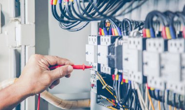 Electrical engineer checking the operation of electrical control cabinet, maintenance concept.