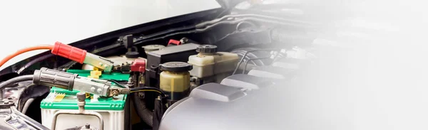 Close up Charging car battery with electricity through jumper cables.