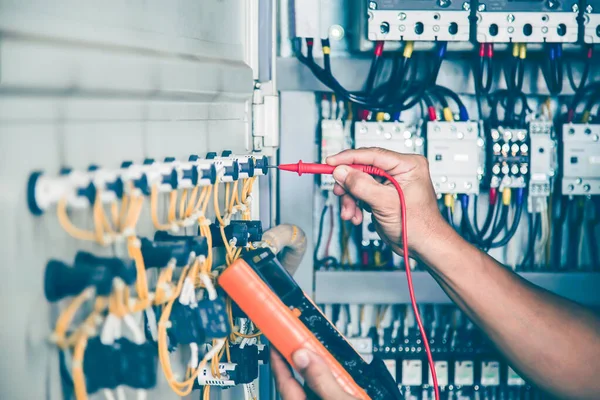 An electrical engineer is inspecting the operation of an electrical control cabinet. maintenance concept