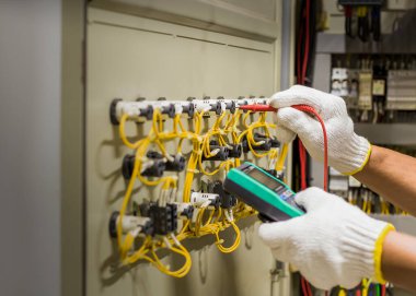 An electrical engineer is inspecting the operation of an electrical control cabinet. maintenance concept