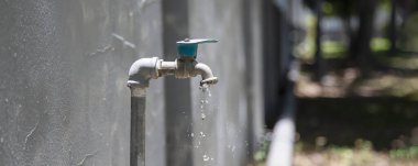 Evin dışındaki eski musluk damlıyor.