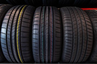 Lastik dükkanındaki yeni lastikleri kapat. Otomobil mağazasında araba lastikleri askıda. 