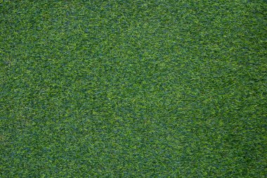 Açık hava sporları ve sporla ilgili işler için tasarlanmış yapay çimenlerin yeşil duvarı ve yeşil arka planı.