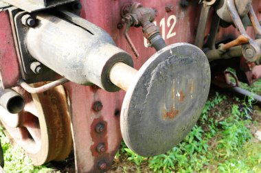 Buharlı lokomotifin ön kısmı. Tekerleklerin, pistonların ve tamponların bir kısmı görünür..