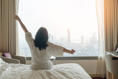Tembel bir günde, Asyalı bir kadınla otel istirahatı. Hafta sonu rahat bir yatak odasında uykusundan uyanıyor. Şehir manzarasına bakıyor.
