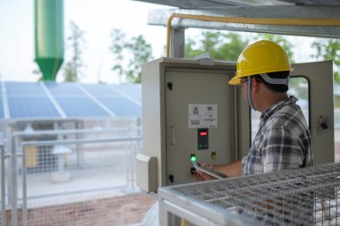 Güneş veya alternatif enerjili yeraltı suyu pompalama istasyonundaki teknisyen kontrol ve izleme için bir tablet kullanır.