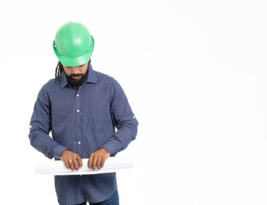 Mimar, yeşil şapkalı, mavi gömlekli ve planlı genç yetişkin bir latin. Karayipler