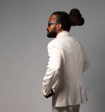 afro cuban with dreadlocks in suit with pink tshirt 