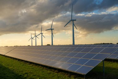 Rüzgar çiftliğinde rüzgar türbini ve güneş panelleri enerji üretenler