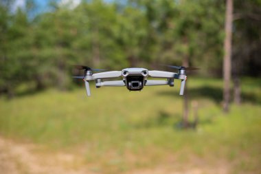Mavi gökyüzünde uçan bir dron. Kameralı modern kompakt drone. Arkaplan kavramı.