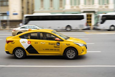 Rusya, Moskova - 20 Ekim 2021: Sarı Yandex taksisiyle şehir trafiği. Moskova sokaklarında hızlı hareket eden sarı taksi arabası.