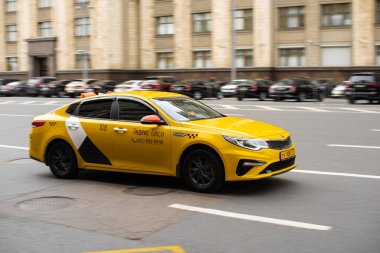 Rusya, Moskova - 20 Ekim 2021: Sarı Yandex taksisiyle şehir trafiği. Moskova sokaklarında hızlı hareket eden sarı taksi arabası.