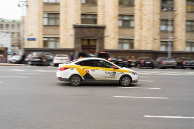 Rusya, Moskova - 20 Ekim 2021: Sarı Yandex taksisiyle şehir trafiği. Moskova sokaklarında hızlı hareket eden sarı taksi arabası.