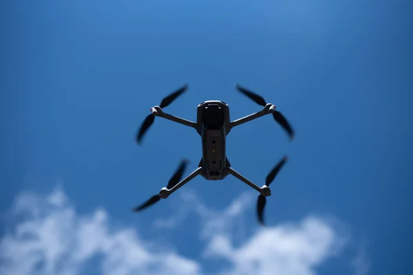 Drone flying in the blue sky. Modern compact drone with a camera. Background concept.