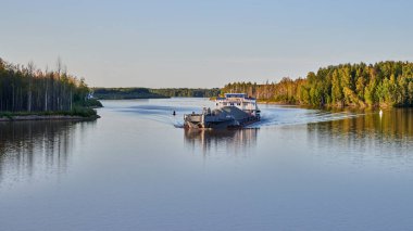 - Rusya. Gün batımında Volga-Baltık kanalının Kovzha nehri. Kuru kargo mavnası yaklaşıyor.