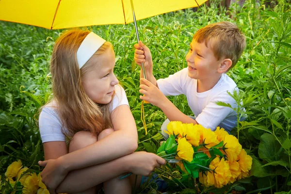 Children walk in the park with umbrella. Boy and girl having fun together. Brother and sister rest and walk on nature