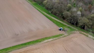 Suffolk, İngiltere 'nin kırsal kesiminde tarla süren bir traktörün hava görüntüsü.