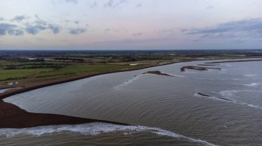 İngiltere 'nin Suffolk kentindeki Shingle Sokağı' nda güneşin sahilin üzerinde batışını gösteren hava görüntüsü.