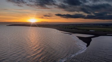 İngiltere 'nin Suffolk kentindeki Shingle Sokağı' nda güneşin sahilin üzerinde batışını gösteren hava görüntüsü.