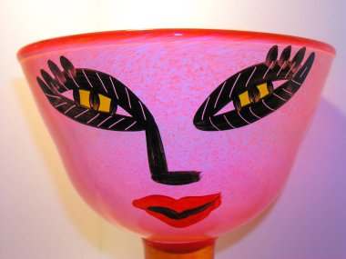 A colourful glass bowl with a human face decoration