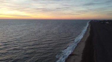 Maggi Hambling 'in Aldeburgh, İngiltere' deki şilte plajındaki Scallop heykelinin gündoğumunda 4k drone görüntüsü.