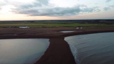 Güneş 'in Suffolk, İngiltere' deki Shingle Caddesi 'nde batarken 4k drone görüntüsü.
