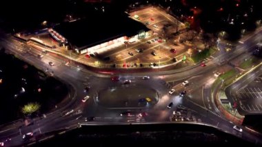 İngiltere 'de gece vakti bir kavşakta gezinen araçların 4k drone görüntüleri.