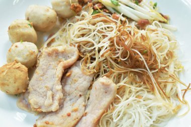  Haşlanmış kuru vermicelli ince pirinç eriştesi dilimlenmiş domuz eti ve köfte soslu siyah soya sosu tabakta.