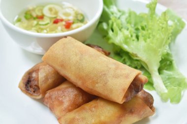  Kızarmış yumurta rulosu doldurulmuş marullu cam şehriye tabakta tatlı acı biber sosu.