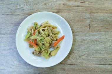  Baharatlı kızarmış karnabahar ve havuç tabağında domuz eti.