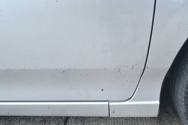  Gümüş renkli araba arka planında ve deseninde inşaat yolundan yayılan siyah nokta asfalt lekesi