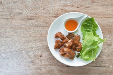  Kızarmış domuz kemiği, sarımsaklı sos ve taze sebze tabağı.