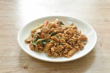  Baharatlı kızarmış fusilli makarna, tavuklu ve sebzeli ve biberli Tayland eritme yemeği.