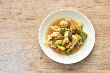  Kızarmış Karnabahar ve brokoliyi tabakta istiridye sosuyla karıştırın.