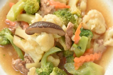  Kızarmış Karnabahar ve brokoliyi tabakta istiridye sosuyla karıştırın.