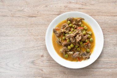  Hindistan cevizi sütlü patlıcanla haşlanmış baharatlı biftek. Tabakta kırmızı köri çorbası.