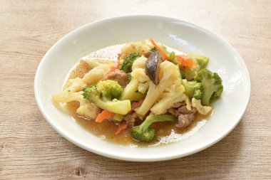  Kızarmış Karnabahar ve brokoliyi tabakta istiridye sosuyla karıştırın.